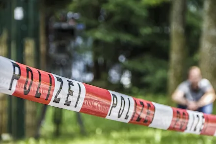 Polizei-Absperrband am Drehort, dahinter unscharf ein Darsteller